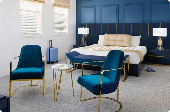 master bedroom with lounge chairs and small table in front of the bed