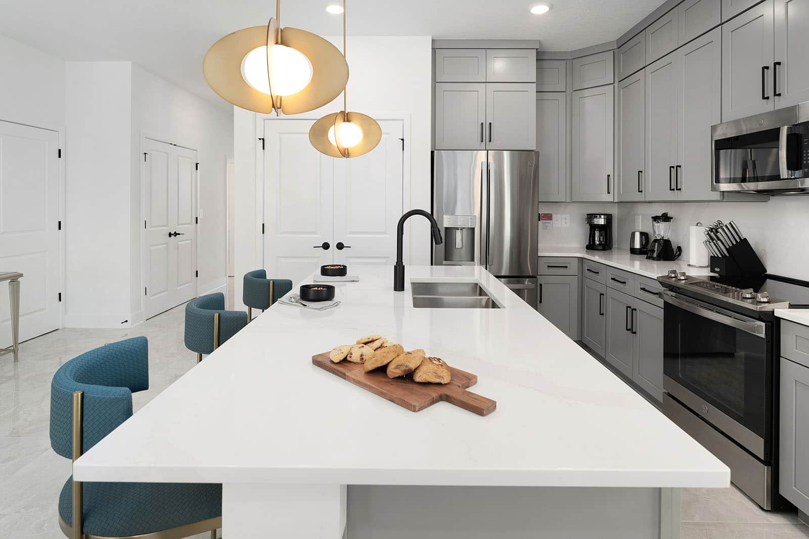 kitchen island with 3 stools and pastries on a cutting board