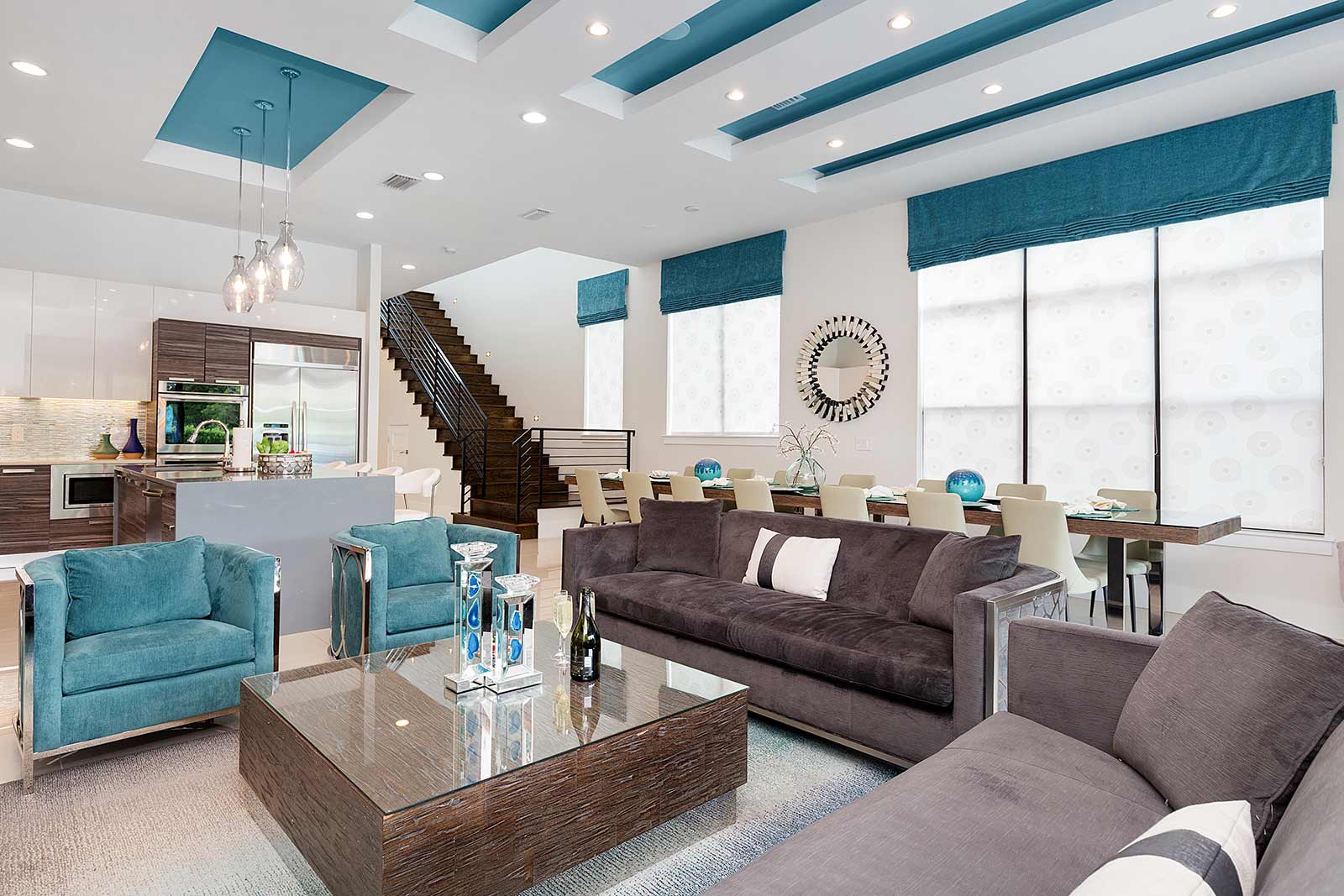 living room with 2 couches and teal armchairs