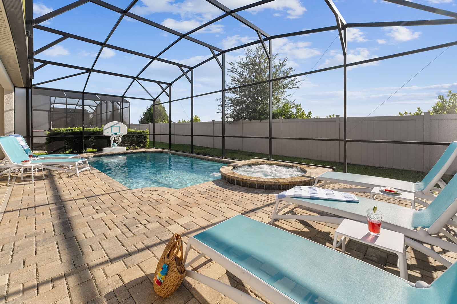 pool and spa with lounge chairs and basketball hoop