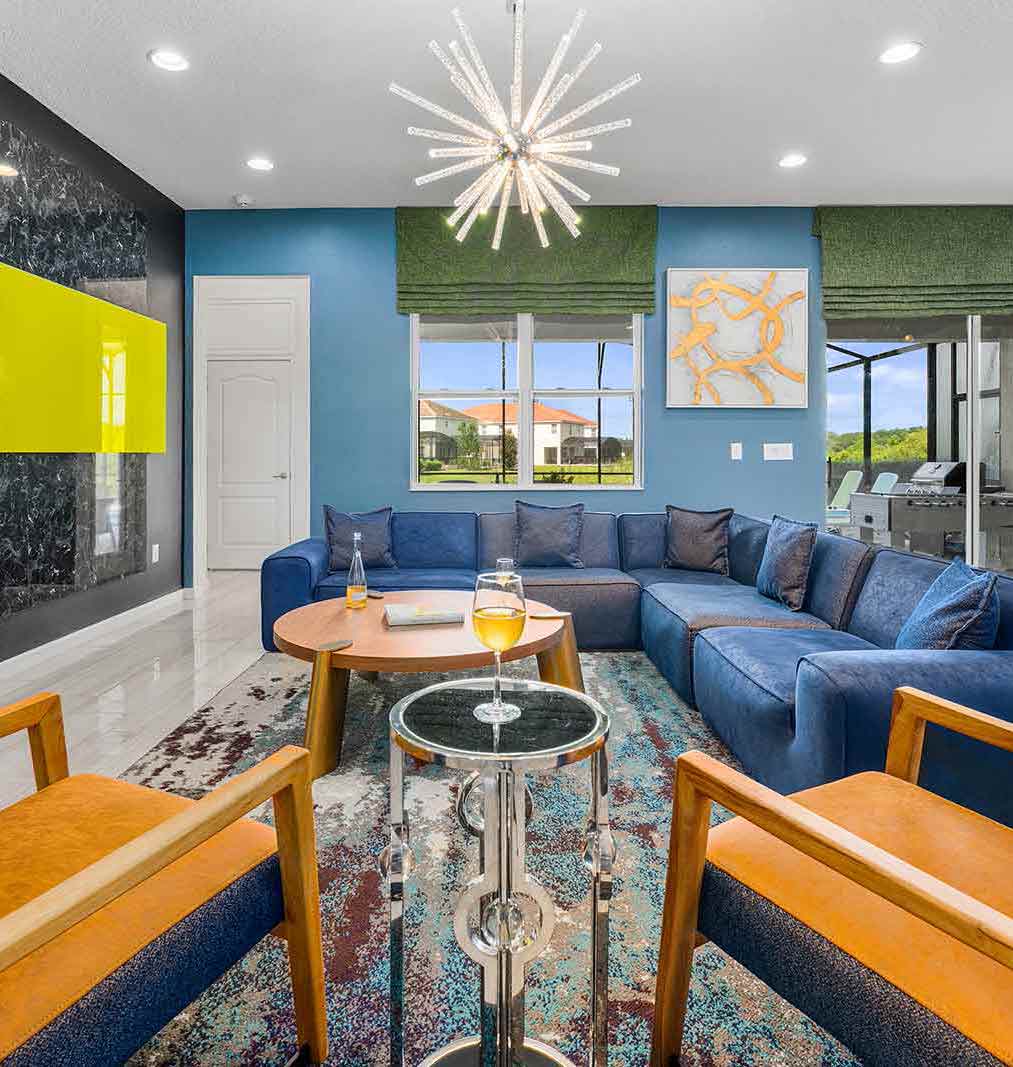 living room with blue l-shaped couch and orange and blue chairs