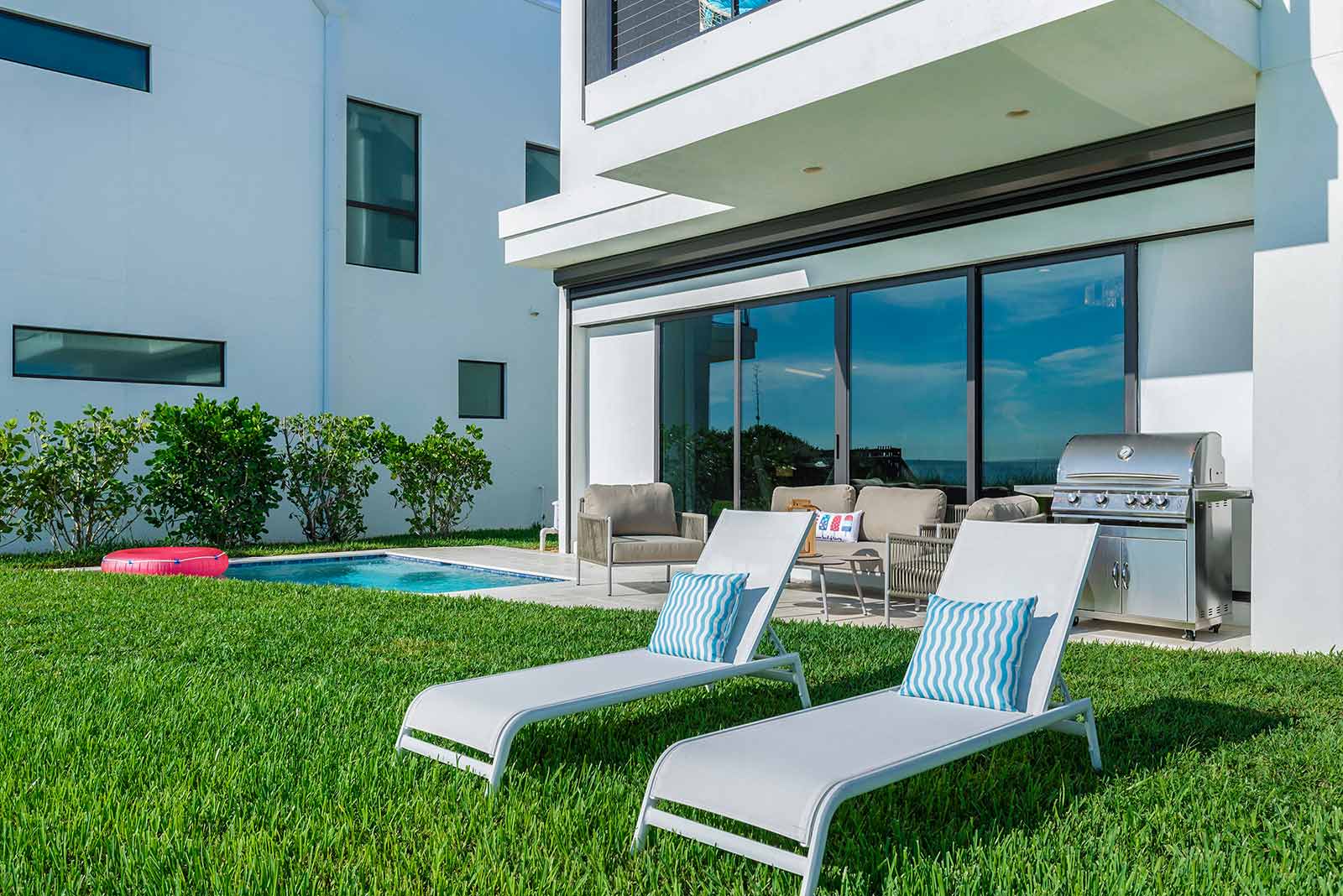 pool with lounge chairs at beachside villa