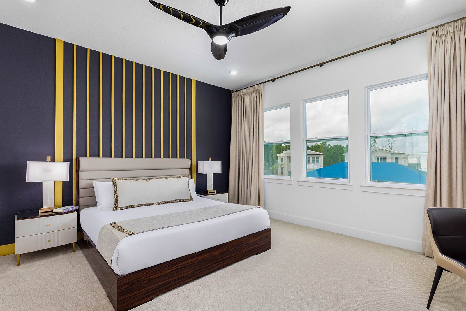 bedroom with king bed and blue wall with gold stripes