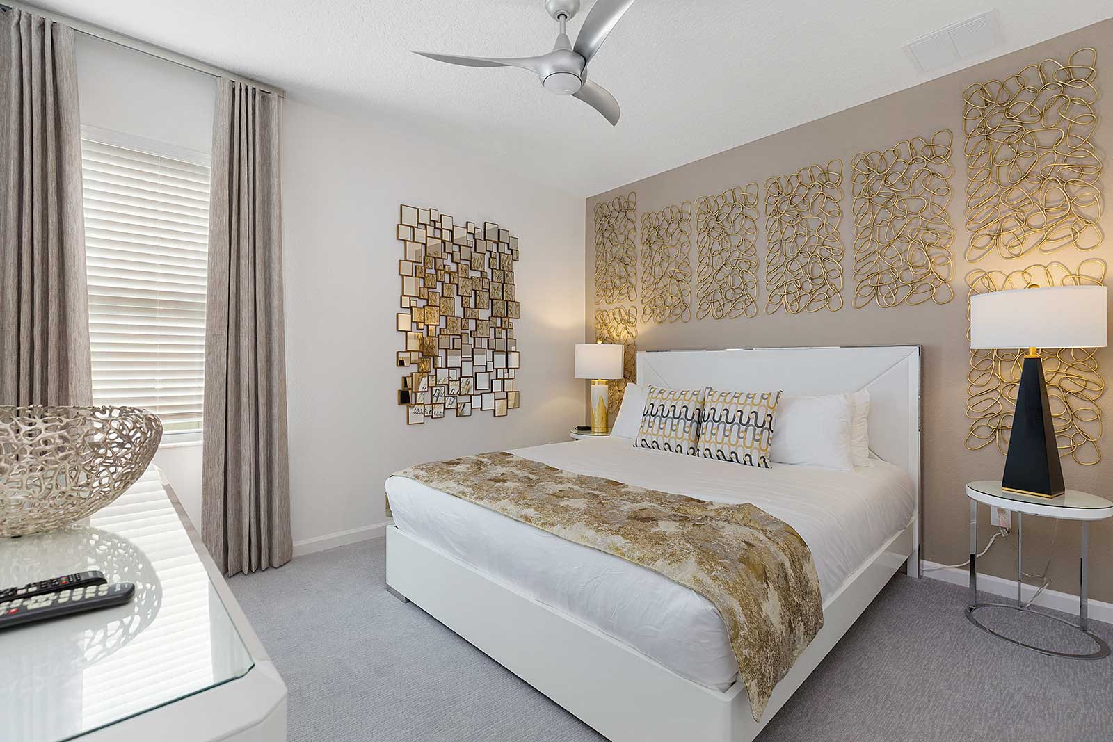 king bedroom with gold patterned wall with bedside table and lamp