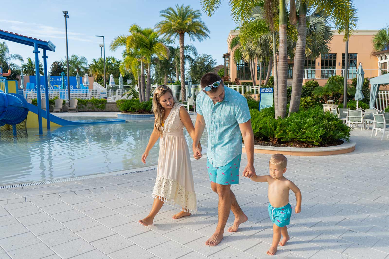 couple walking next to the beach with their child all holding hands
