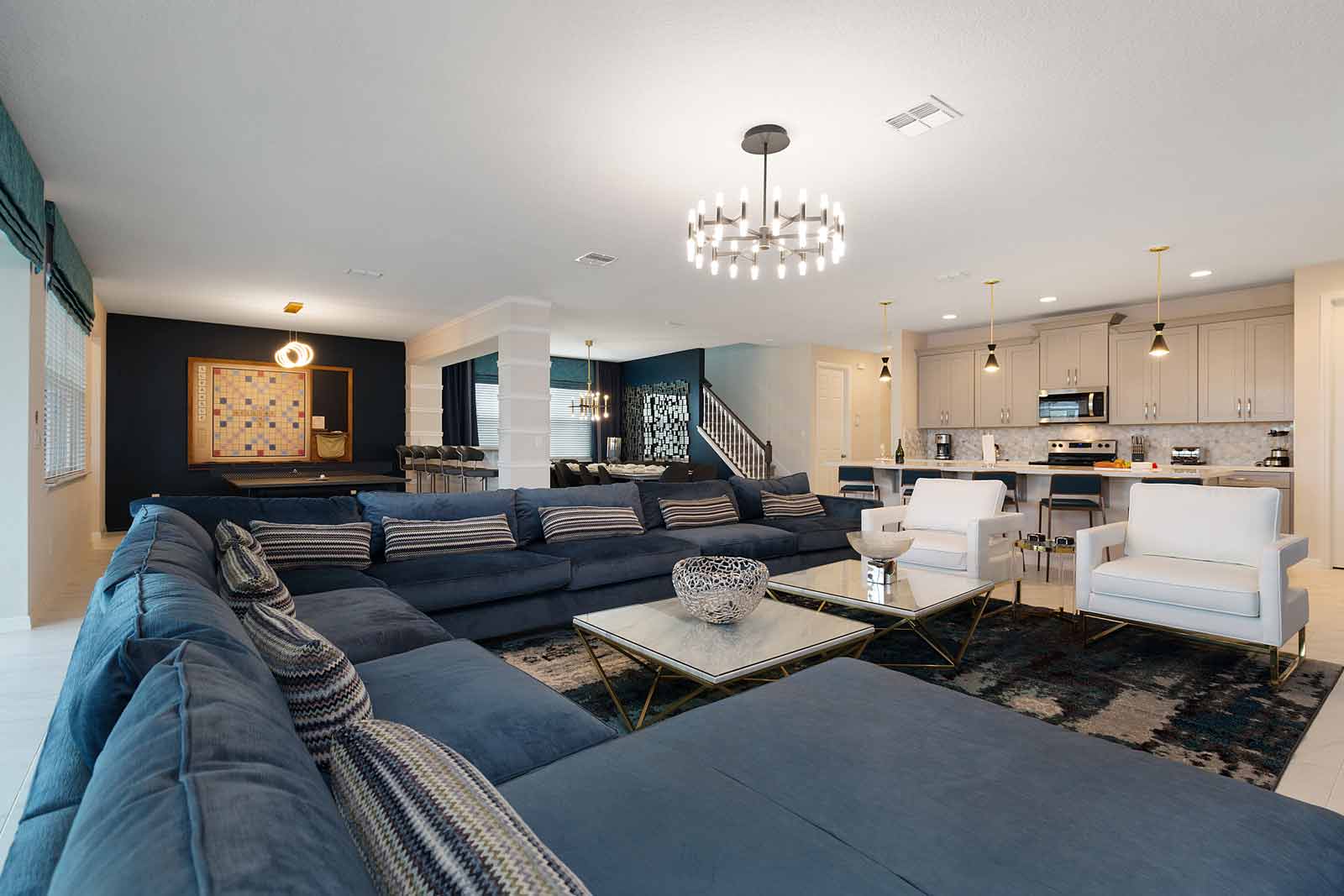 living room with large blue sectional couch and wall scrabble in the background