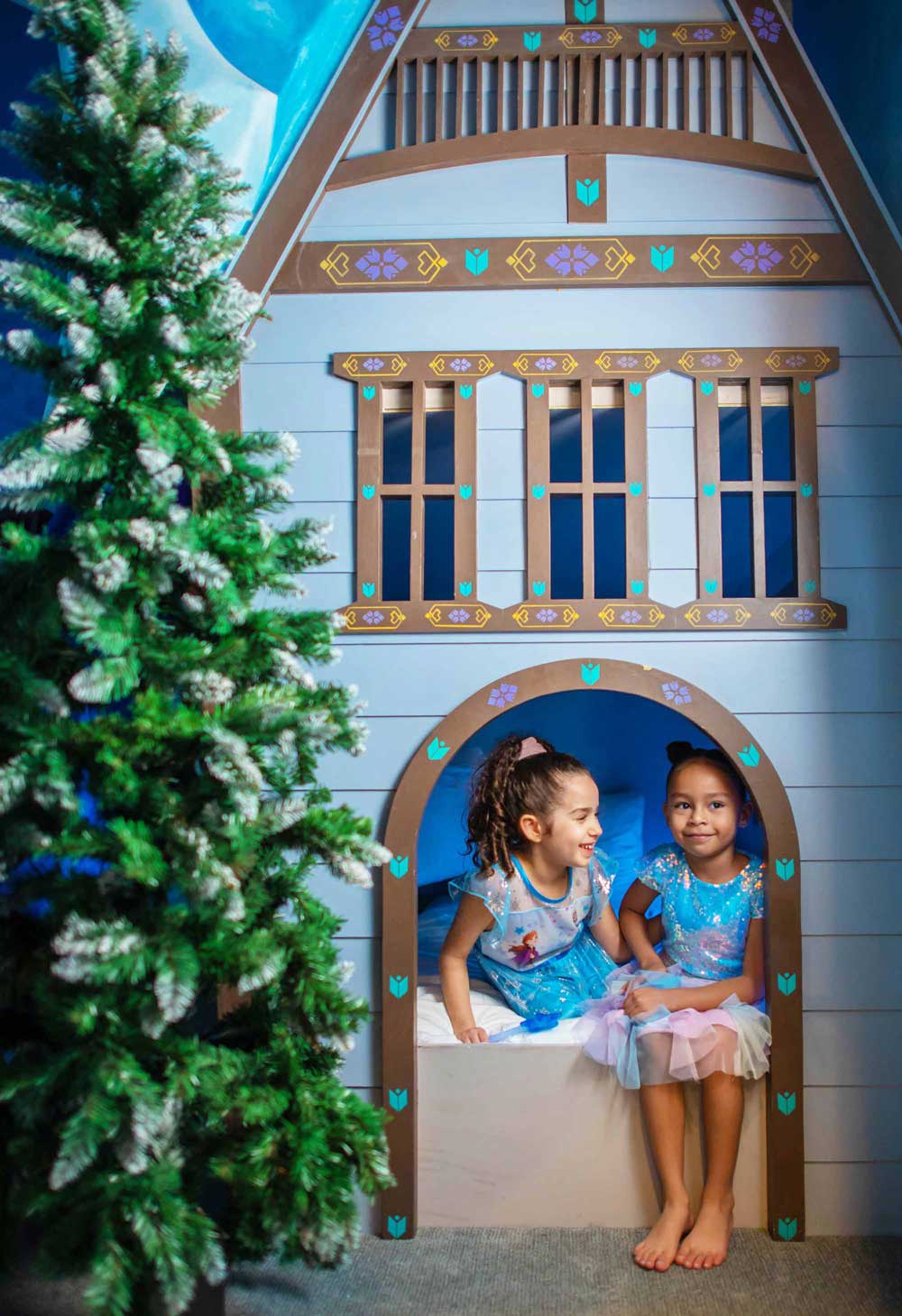 2 girls sitting on a bed in an ice princess theme bedroom