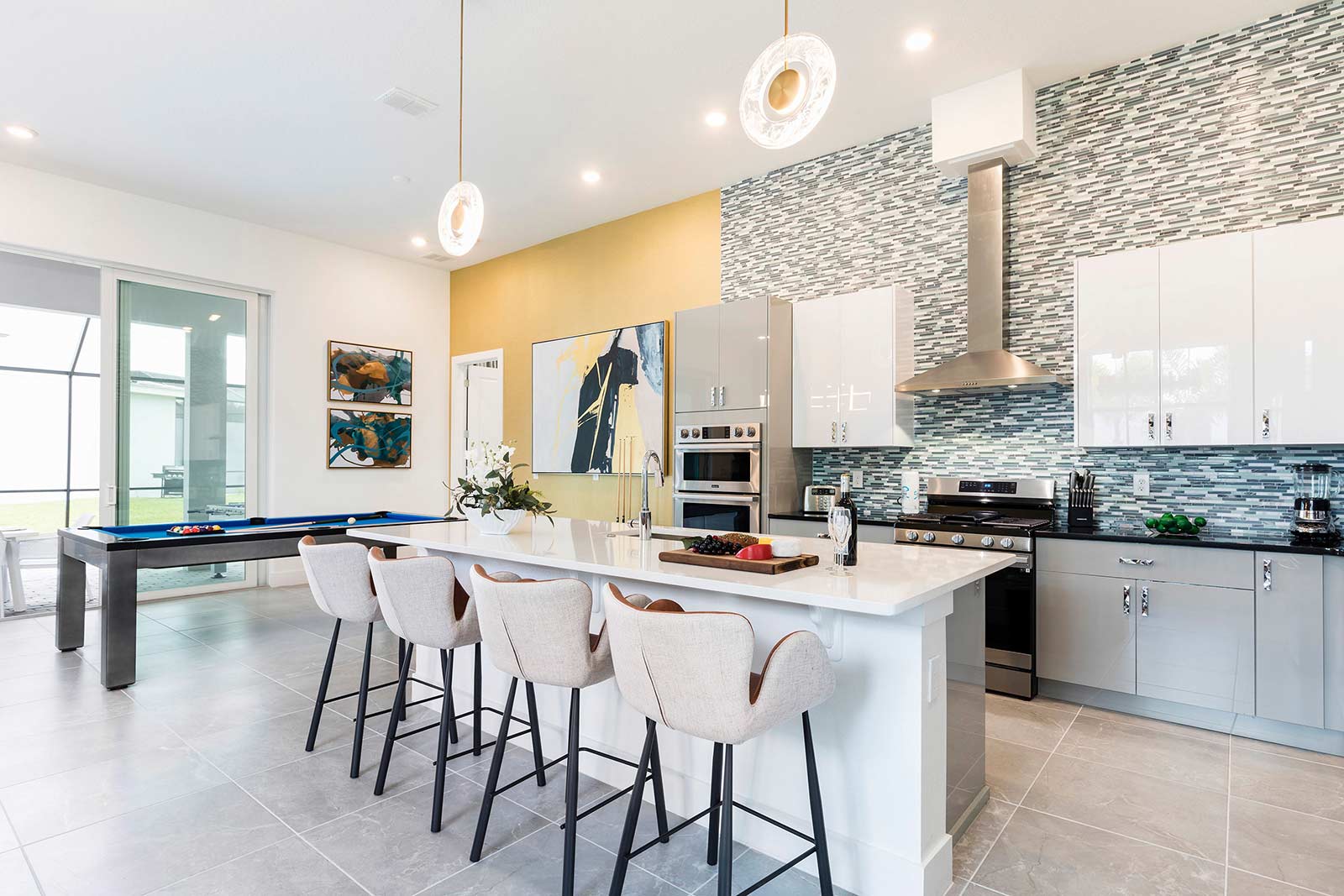 kitchen with island and 4 stools next to pool table