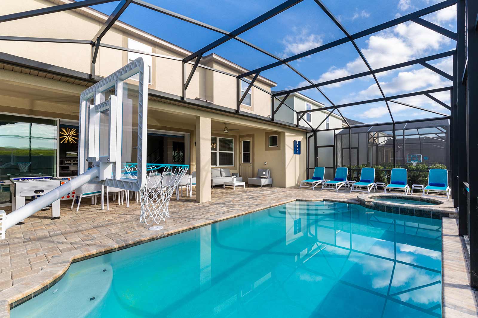 pool with lounge chairs and basketball hoop