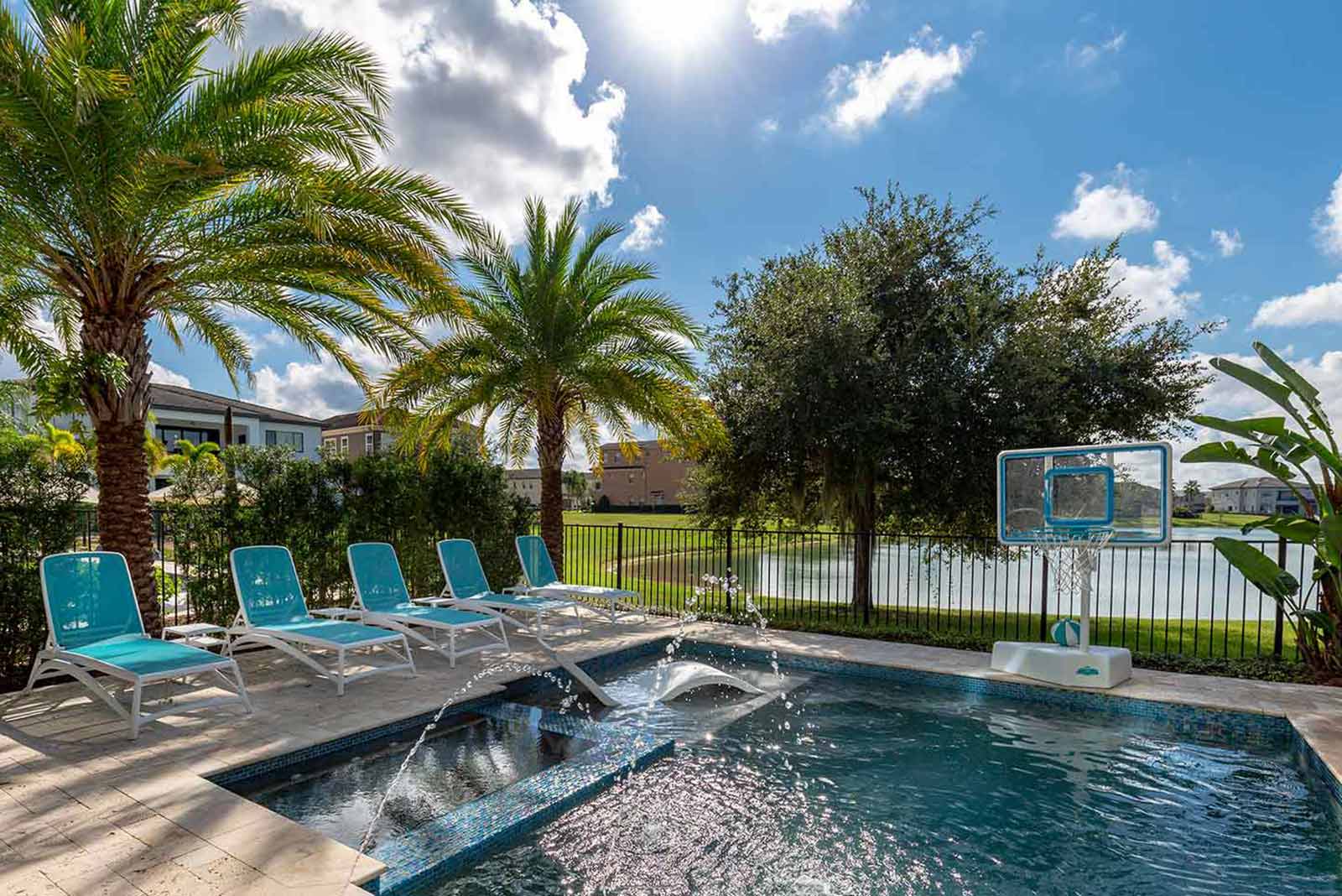 pool with pool basketball and lounge chairs