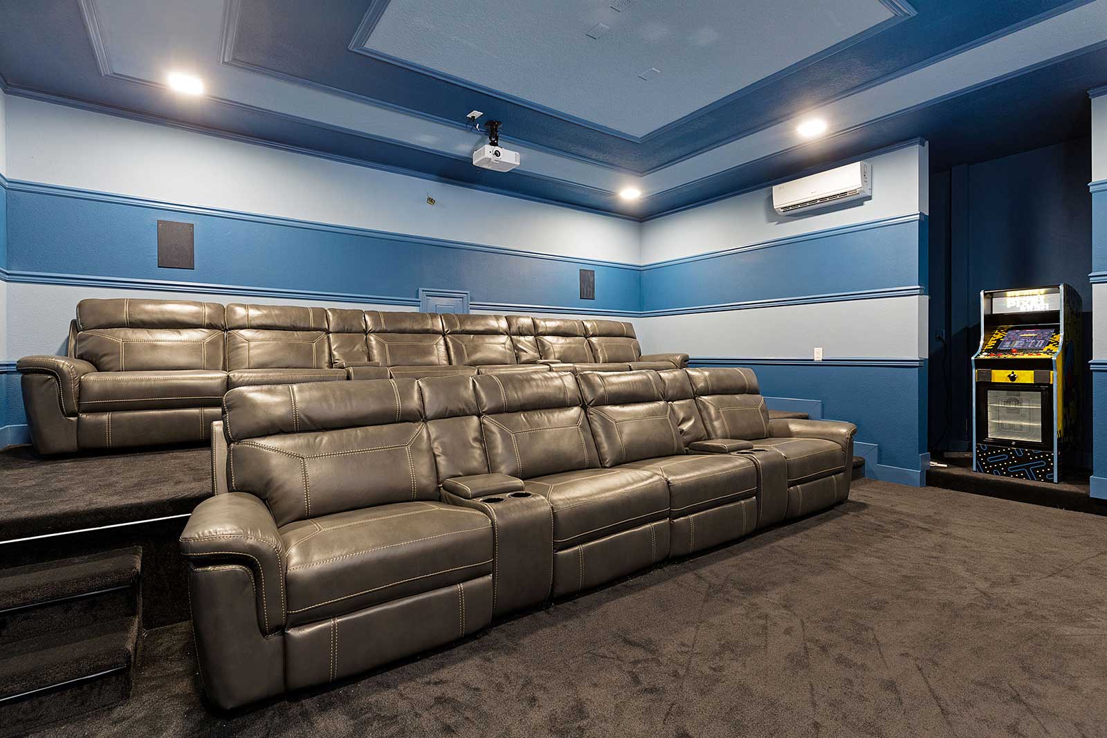 theater with two rows of seating and multi-cade arcade game