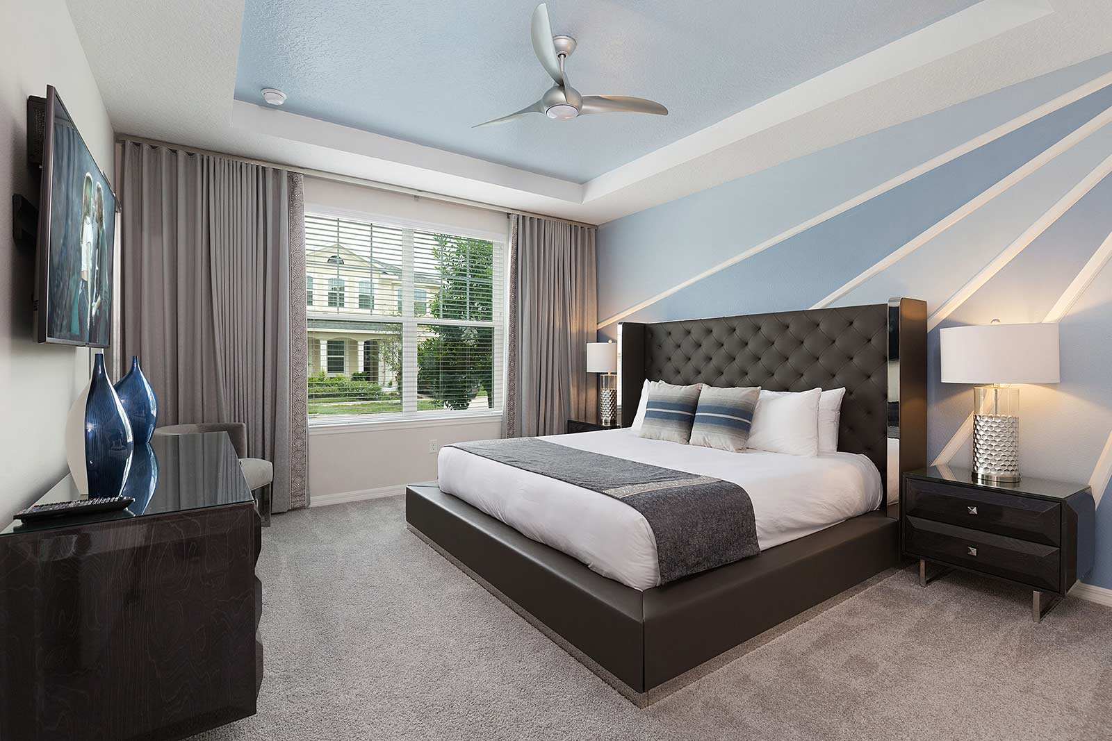 king bedroom with brown bed frame and blue patterned wall