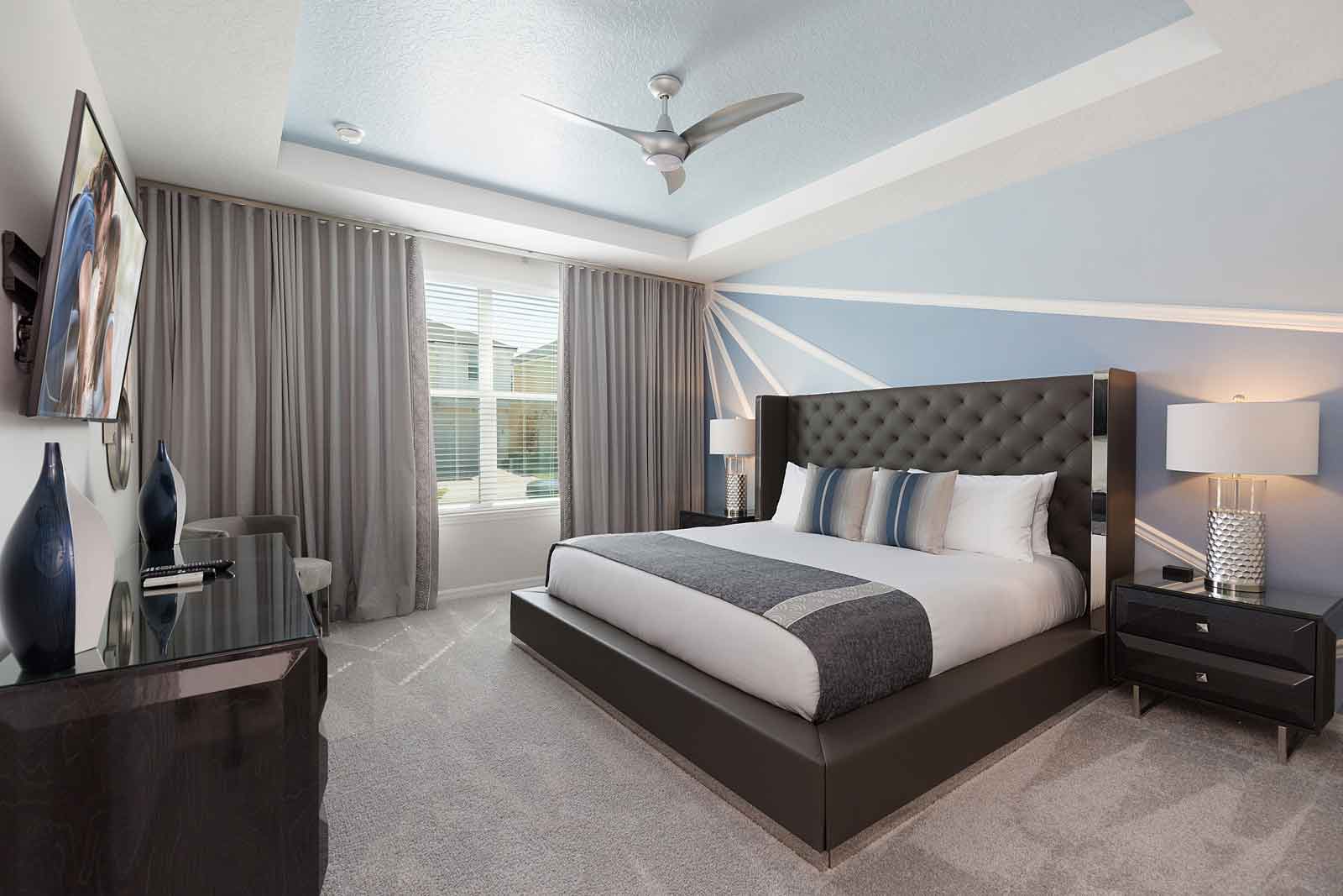 King Bedroom with blue patterned wall and bedside table with a lamp