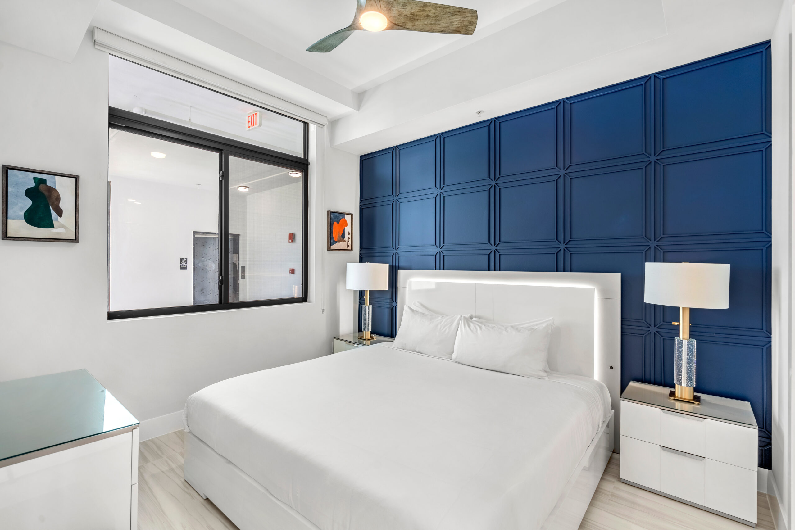 bedroom with white bedding and blue background wall