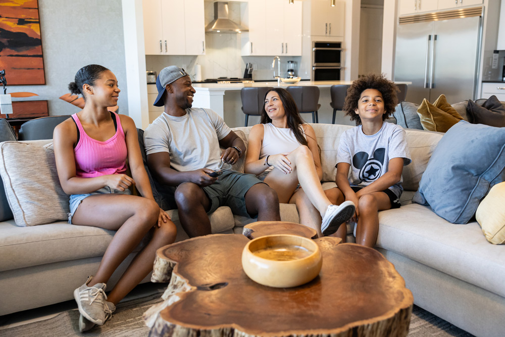Group sitting on a couch socializing in a living room
