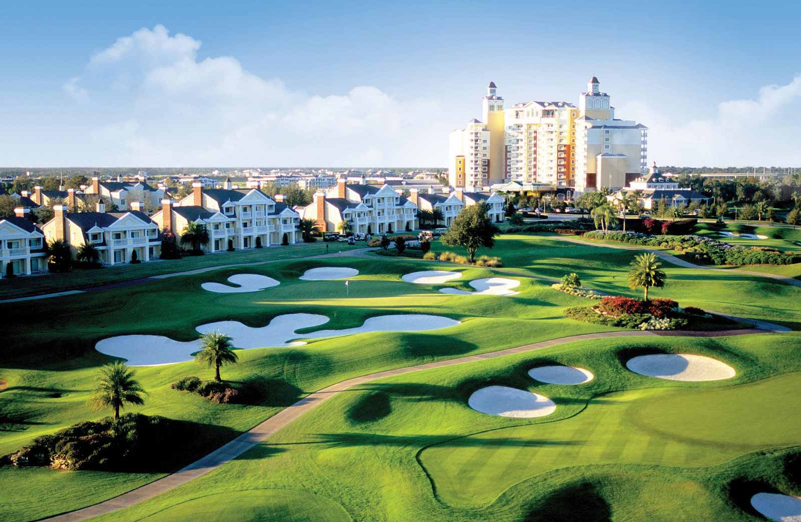 aerial view of golf course with resort buildings in the background